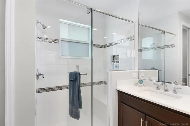 a bathroom with a double vanity sink a mirror and shower