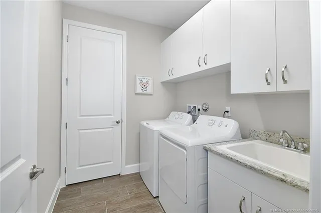 a utility room with cabinets washer and dryer