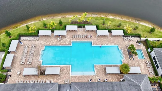 swimming pool view with couches and potted plants