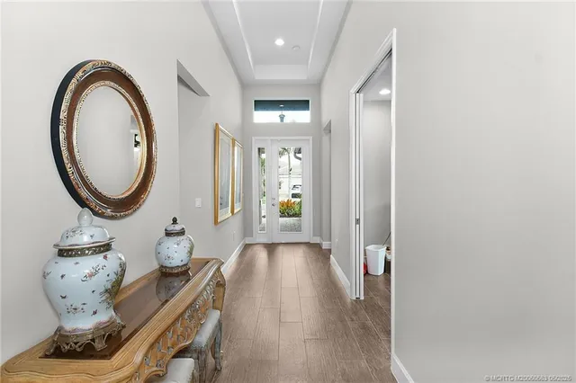 a view of a hallway with wooden floor and front door