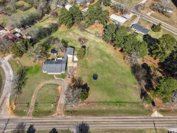 an aerial view of a residential houses with yard
