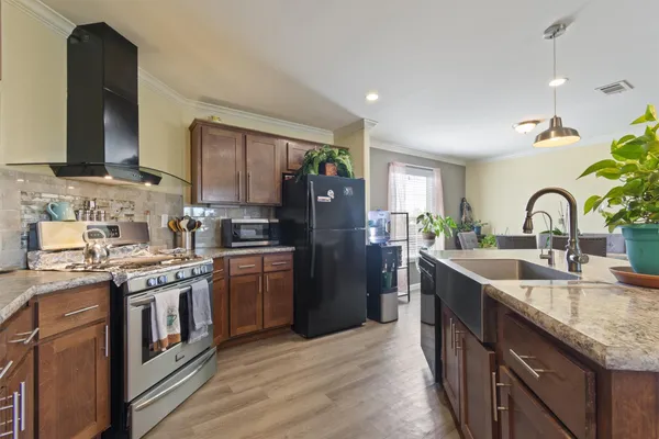 a kitchen with stainless steel appliances granite countertop a sink stove and refrigerator