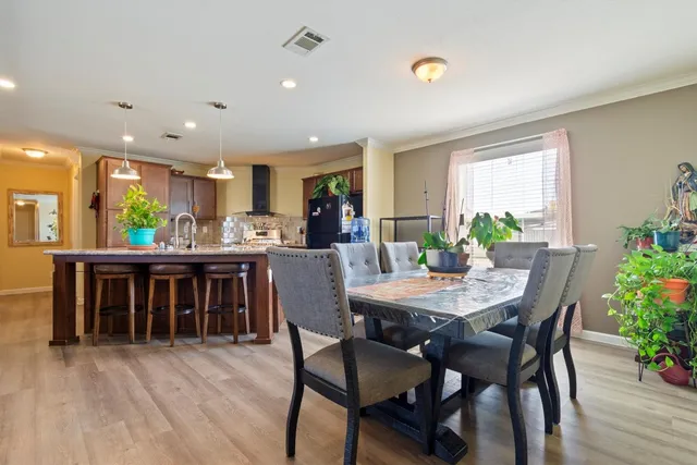 a kitchen with stainless steel appliances kitchen island a table and chairs in it