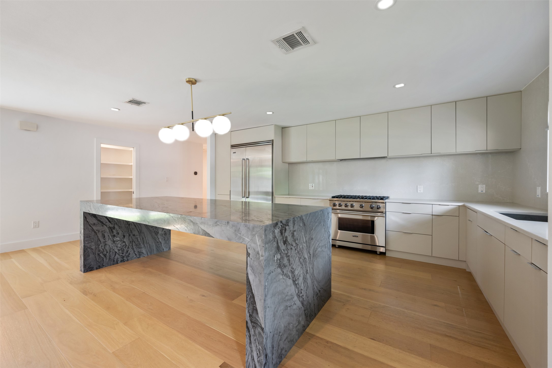8900 Point W Drive Austin, TX 78759 - Photo 13 of 40 An inviting kitchen with a waterfall marble island and lustrous hardwood floors.
