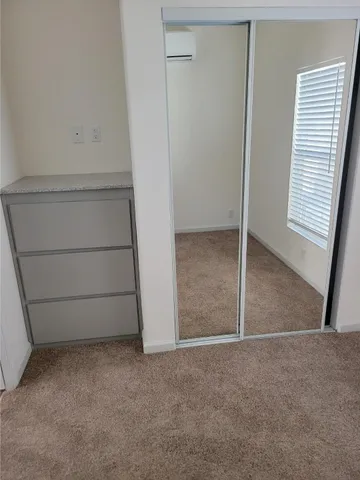 a bedroom with a bed and a refrigerator