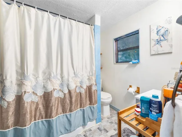 a view of an empty room and kitchen view