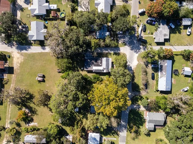 an aerial view of a house with a yard swimming pool and outdoor seating