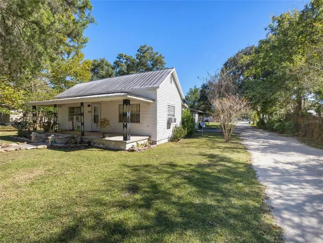 a view of a house with backyard and sitting area