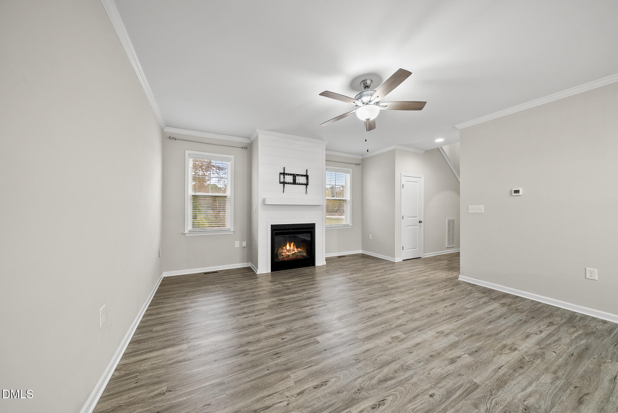 1177 Mudham Road Wendell, NC 27591 - Photo 6 of 30 an empty room with windows a fireplace and a ceiling fan
