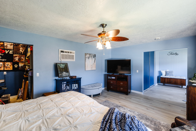 1470 Redwood Tree Street St. George, UT 84790 - Photo 13 of 53 Spacious room featuring wood-finish flooring, a ceiling fan with integrated lighting, and a built-in window air conditioning unit
