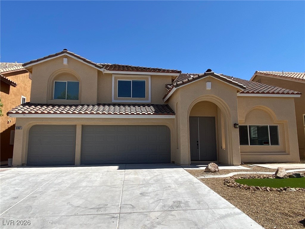 3702 River Canyon Road Las Vegas, NV 89129 - Photo 1 of 35 Mediterranean / spanish-style home featuring a garage, stucco siding, driveway, and a tiled roof