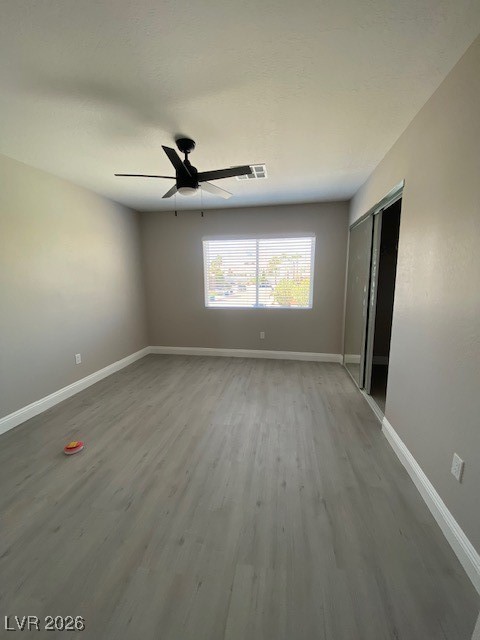 3702 River Canyon Road Las Vegas, NV 89129 - Photo 11 of 35 2-Unfurnished bedroom featuring light wood-style floors, a closet, and a ceiling fan