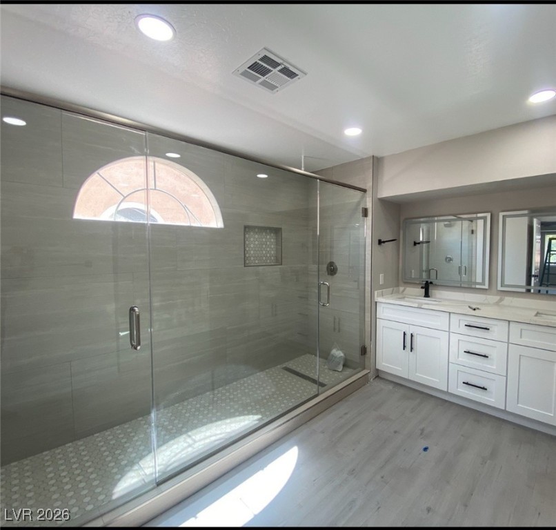 3702 River Canyon Road Las Vegas, NV 89129 - Photo 16 of 35 Bathroom featuring double vanity, a stall shower, light wood finished floors, and recessed lighting