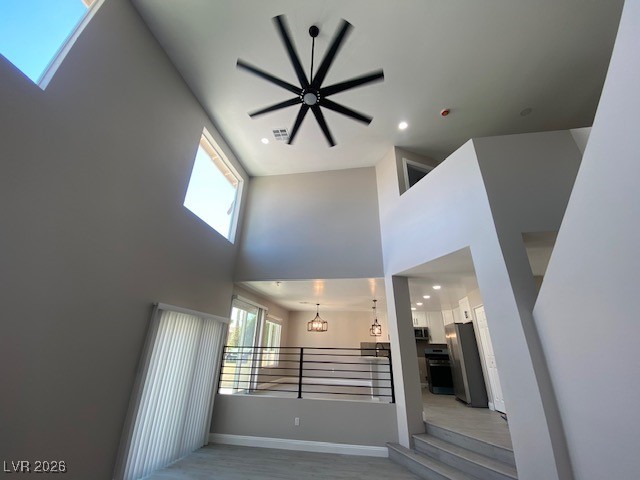 3702 River Canyon Road Las Vegas, NV 89129 - Photo 21 of 35 Unfurnished living room with a high ceiling, recessed lighting, a skylight, and wood finished floors