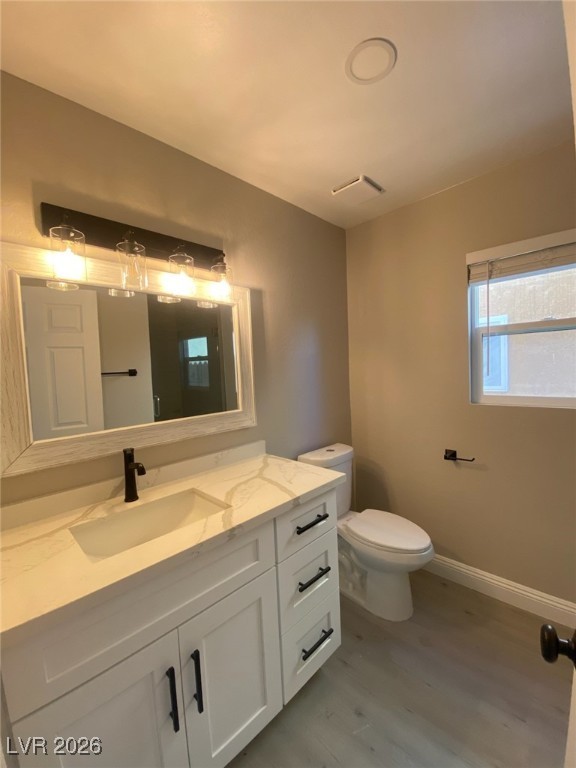 3702 River Canyon Road Las Vegas, NV 89129 - Photo 32 of 35 Half bath with light wood-style floors and vanity down stairs