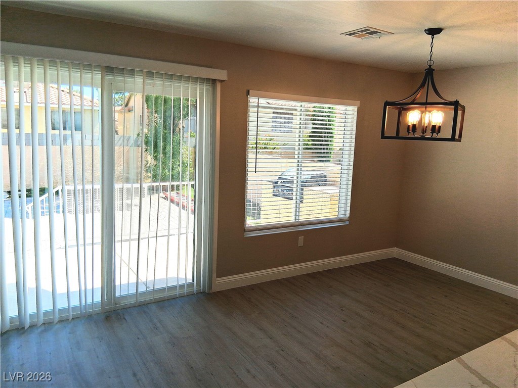 3702 River Canyon Road Las Vegas, NV 89129 - Photo 34 of 35 Unfurnished dining area with dark wood-style flooring and a chandelier