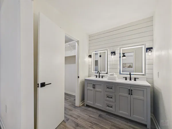 a bathroom with a double vanity sink a mirror and a shower