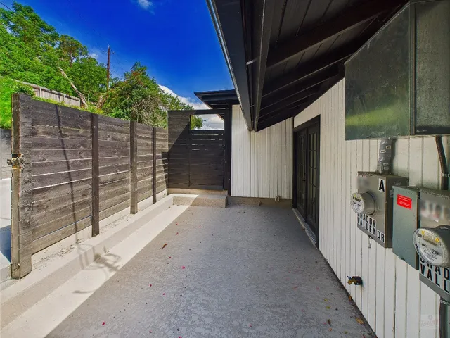 a view of a pathway of a house with wooden fence