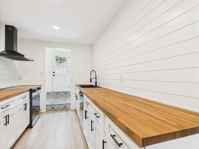 a kitchen with granite countertop white cabinets and white appliances