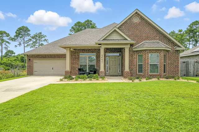 a view of a white house with a big yard and potted plants