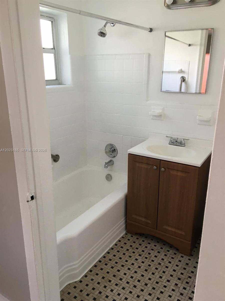 520 Southwest 4th Street, Unit 4 Miami, FL 33130 - Photo 7 of 12 a bathroom with a bathtub sink and mirror