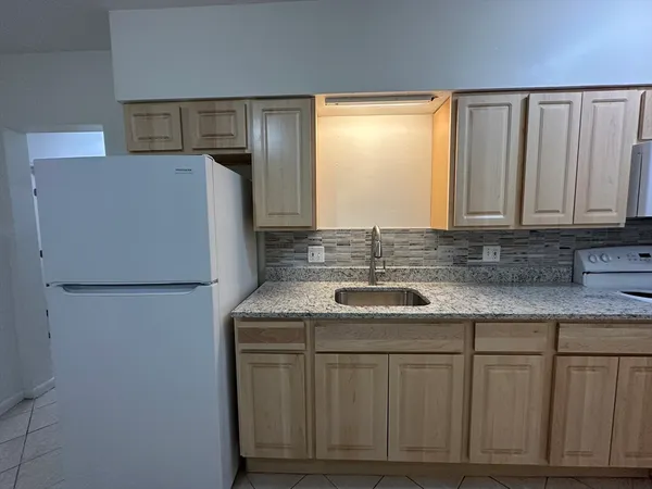 a kitchen with stainless steel appliances granite countertop a refrigerator sink and cabinets
