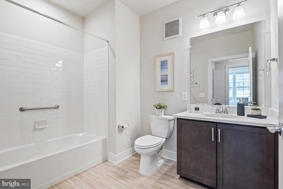 2319 Field Point Road, Unit 107 Herndon, VA 20171 - Photo 21 of 30 a bathroom with a toilet a sink a bathtub and a mirror