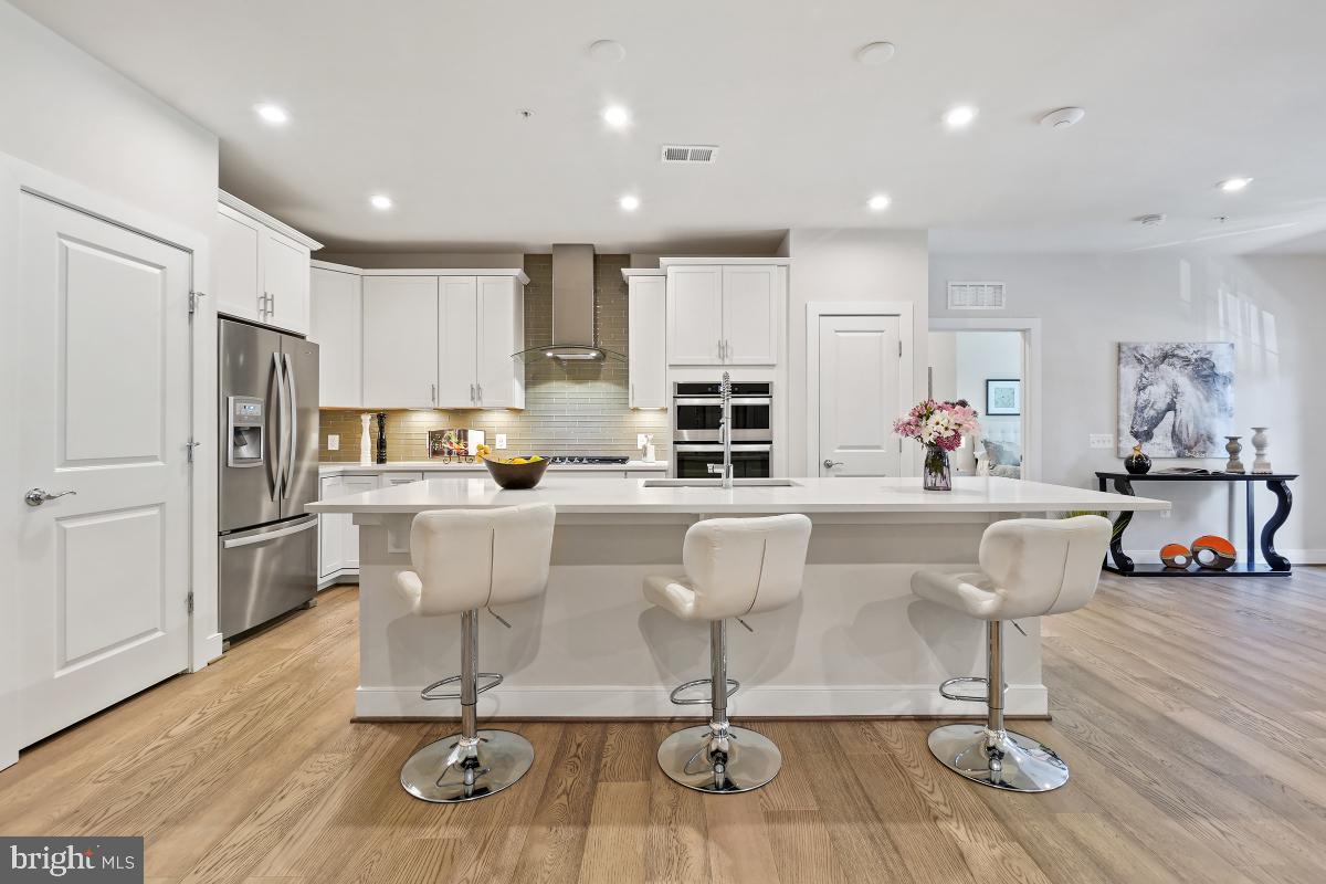 2319 Field Point Road, Unit 107 Herndon, VA 20171 - Photo 3 of 30 a kitchen with stainless steel appliances kitchen island granite countertop a refrigerator and a stove top oven