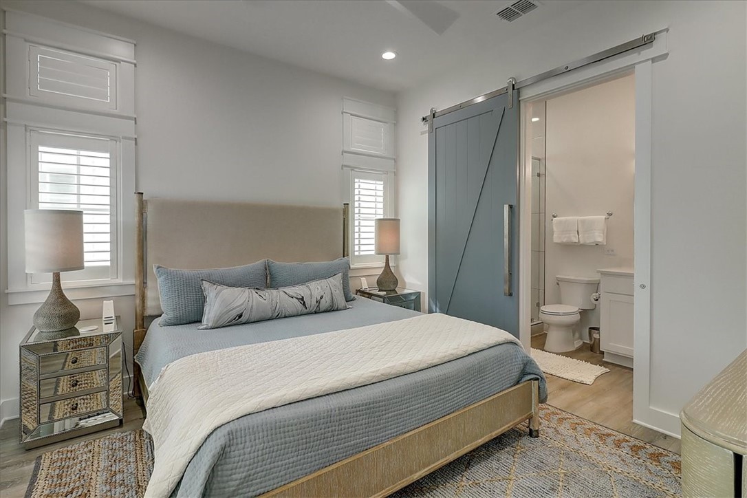 204 Round Road Port Aransas, TX 78373 - Photo 15 of 33 a bedroom with a large bed and a chandelier