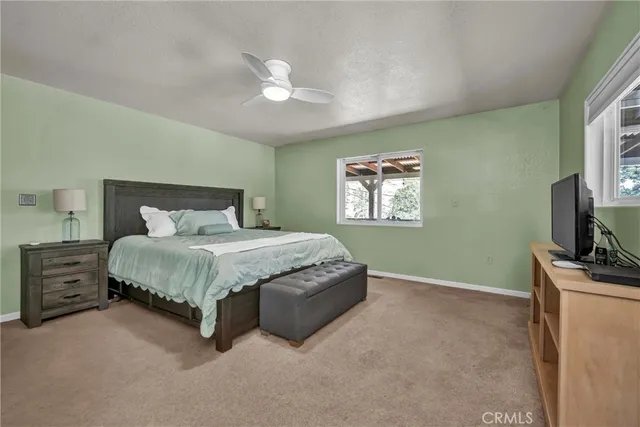 a spacious bedroom with a bed and a flat screen tv