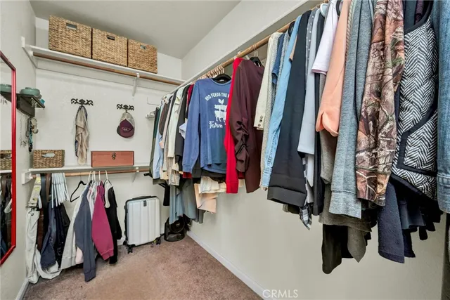 a view of walk in closet with clothes