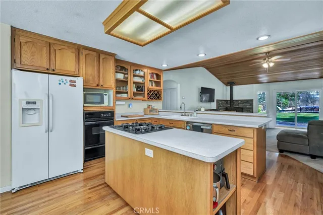 a kitchen with stainless steel appliances granite countertop a stove refrigerator sink and dishwasher with wooden floor
