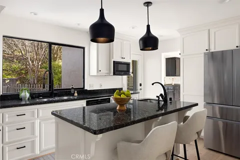 a kitchen with granite countertop a sink a stove and cabinets