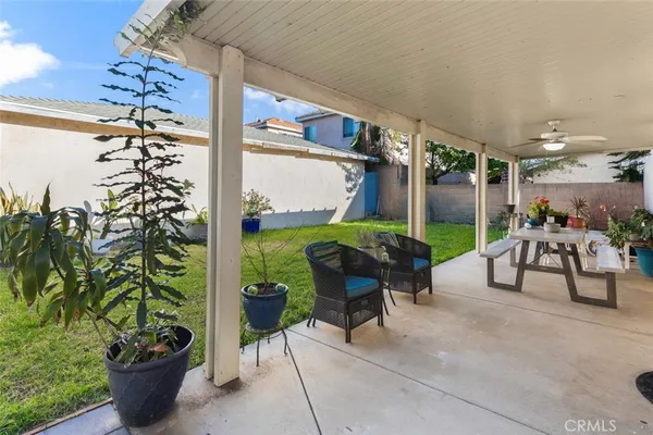 a view of a patio with table and chairs potted plants with wooden fence