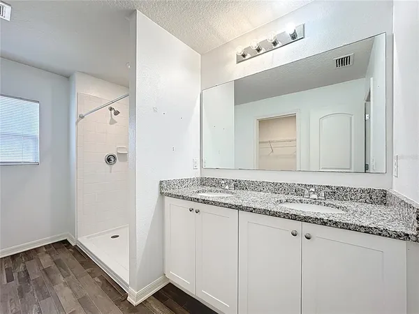 a bathroom with a granite countertop sink and a mirror