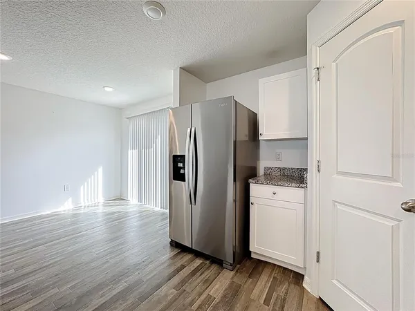 a kitchen with stainless steel appliances a refrigerator and wooden floor