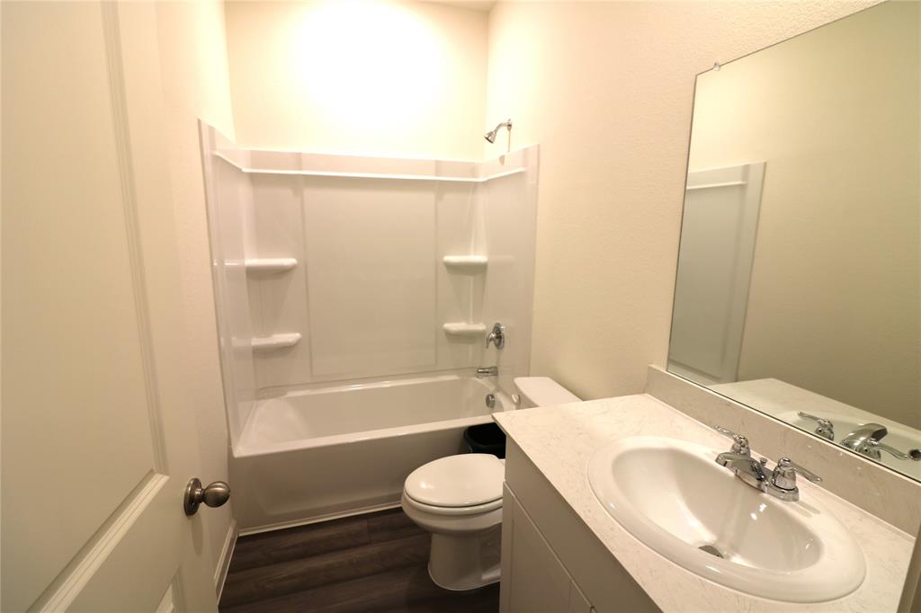 1301 Elliott Road Howe, TX 75459 - Photo 17 of 27 White vanity with an integrated sink, polished chrome faucet, and expansive wall-mounted mirror