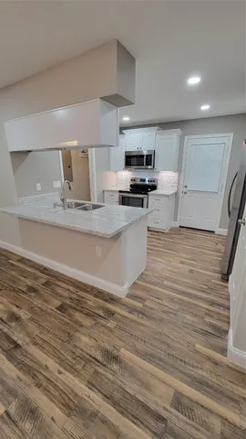 a view of kitchen with microwave stove refrigerator and cabinets