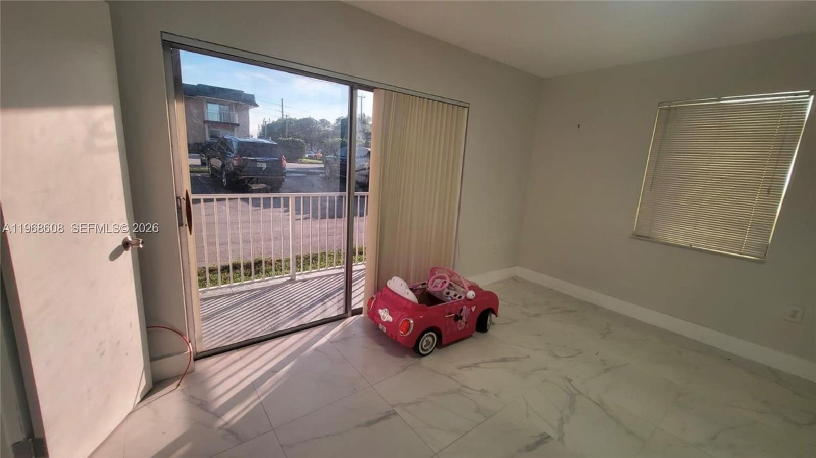 5425 Southwest 77th Court, Unit 102D Miami, FL 33155 - Photo 13 of 22 a room with toys and a floor to ceiling window