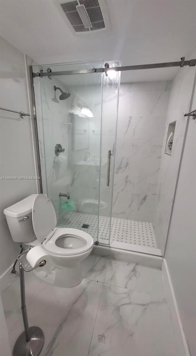 5425 Southwest 77th Court, Unit 102D Miami, FL 33155 - Photo 16 of 22 a bathroom with a toilet and a shower