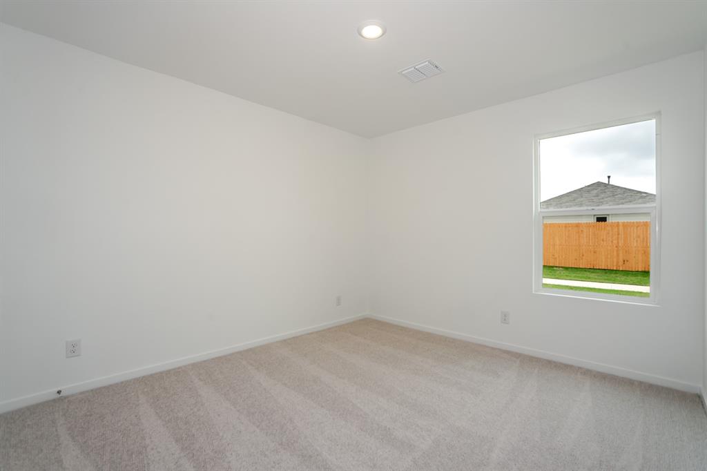 1419 Merlin Blf Street Forney, TX 75126 - Photo 19 of 24 Bright interior room featuring a single window, white walls, and light-toned carpet flooring