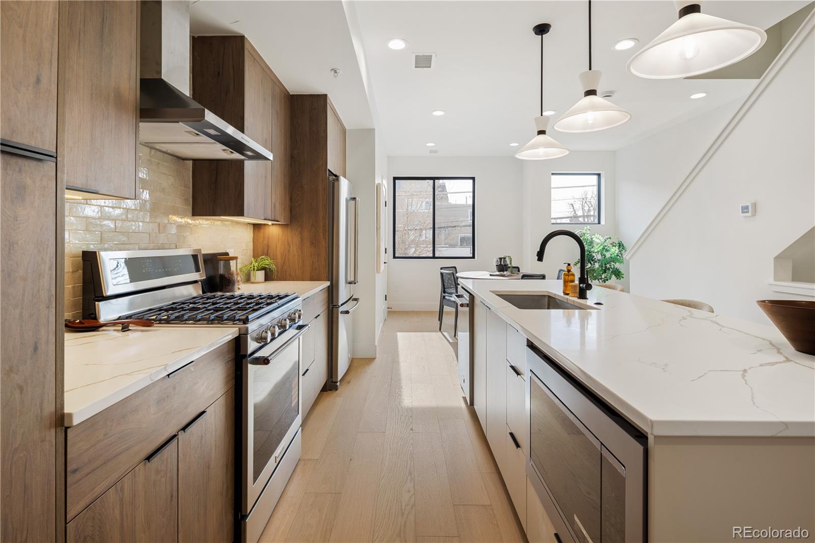 4517 Tennyson Street Denver, CO 80212 - Photo 10 of 28 a kitchen with stainless steel appliances a sink stove and cabinets