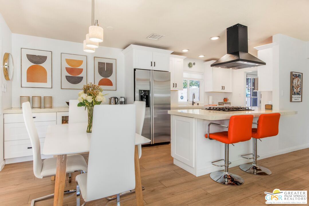 73940 Mountain View Avenue Palm Desert, CA 92260 - Photo 11 of 52 a dining room with granite countertop kitchen island stainless steel appliances a dining table chairs sink and white cabinets