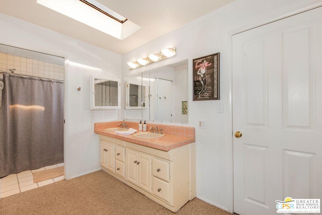 73940 Mountain View Avenue Palm Desert, CA 92260 - Photo 29 of 52 a bathroom with a granite countertop sink a mirror a vanity and shower