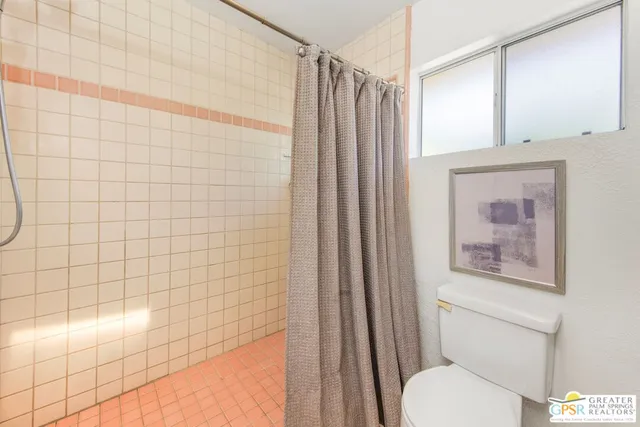 a bathroom with a toilet and a shower