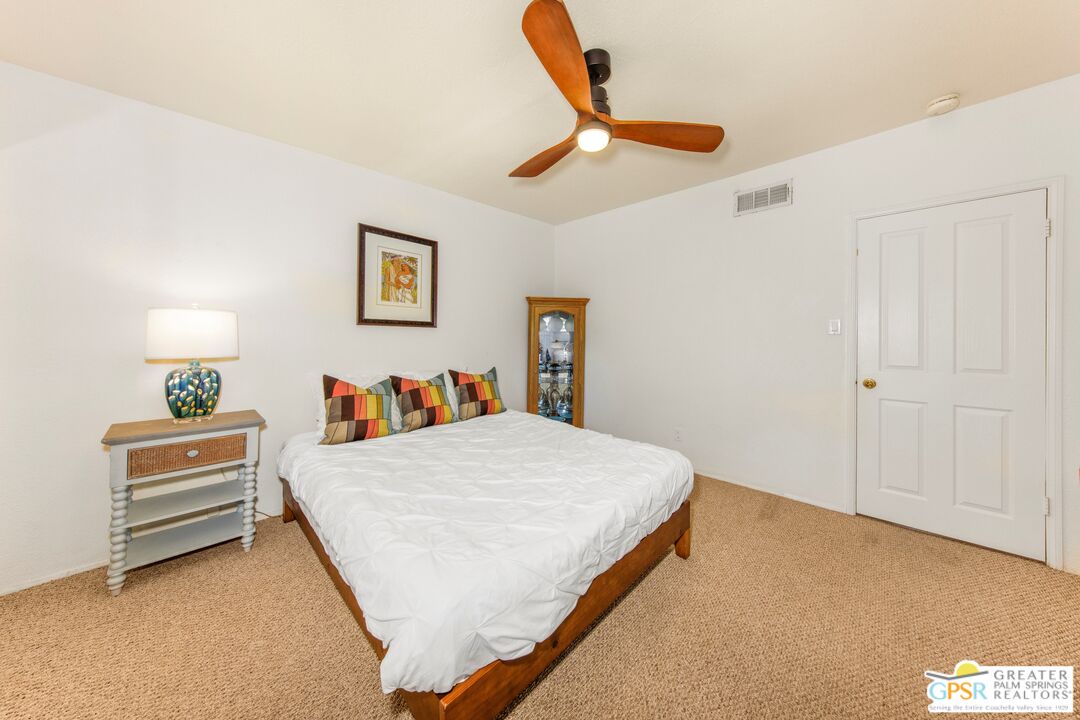 73940 Mountain View Avenue Palm Desert, CA 92260 - Photo 33 of 52 a bedroom with a bed and a chandelier