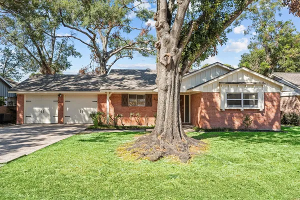 a front view of a house with a yard and trees