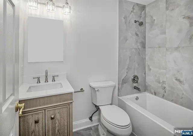 a bathroom with a sink toilet vanity and shower