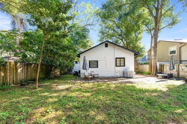 a view of a yard with a house and a large tree