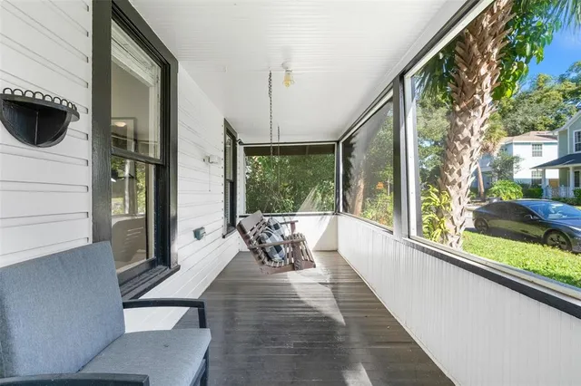 a view of a living room with a floor to ceiling window and wooden floor